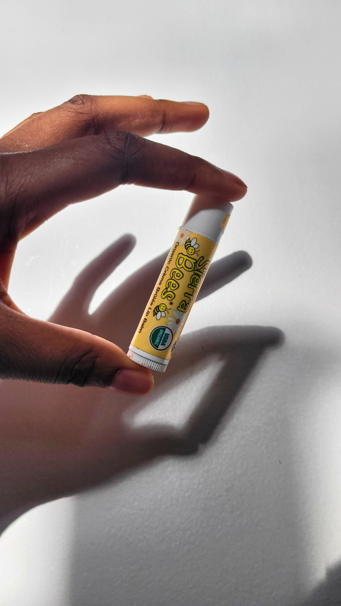 a ugc creator holding a small tube of lip balm