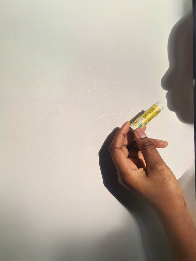 an aesthetic photo of a ugc creator holding a lipbalm